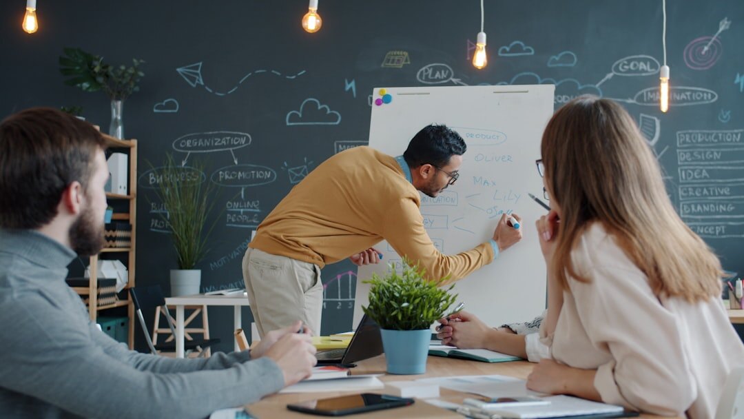 Consultants writing a scaling roadmap on a glass whiteboard